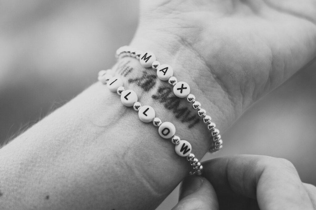 A black and white photo of a woman's wrist adorned with two elegant bracelets.