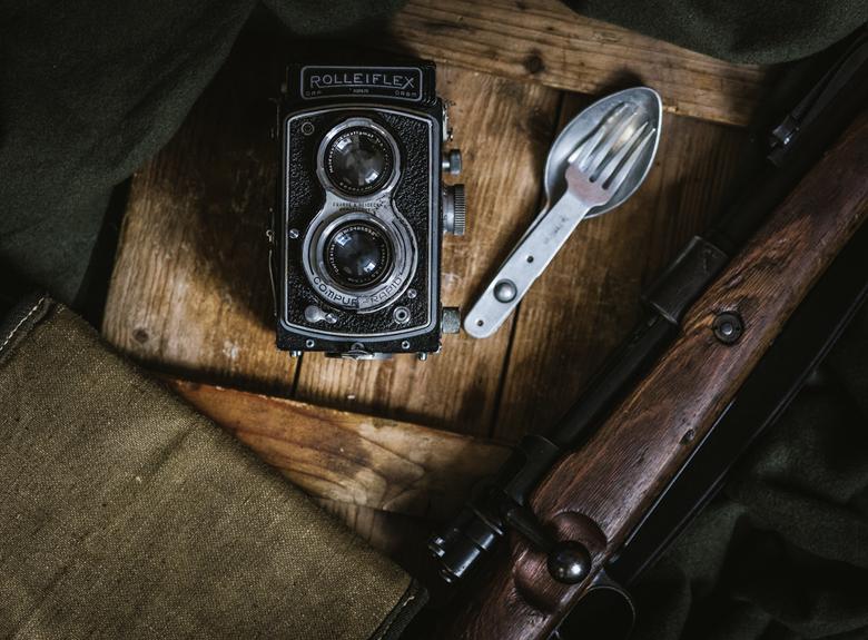 An old camera and a spoon on a wooden table, perfect for capturing memorable moments while you learn German online.